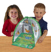 Two children smiling at camera standing behind green, tent-shaped habitat with clear viewing panel, fold-out life cycle learning tool and Painted Lady butterflies fluttering inside.