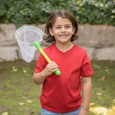 Boy in red shirt standing holding a butterfly net