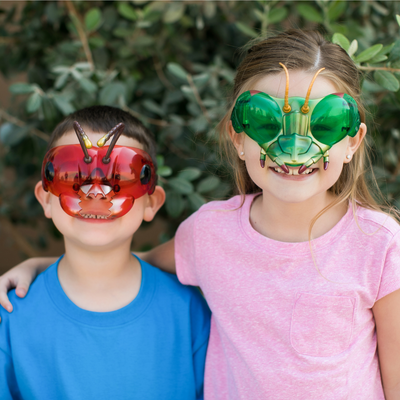 Boy and girl children wearing red and green insect themed goggles