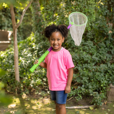 Little girl smiling holding green and purple butterfly net