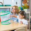 Teacher and student looking into Butterfly Garden butterfly habitat with a Cup of Caterpillars